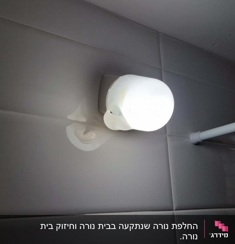 מנורת קיר מוארת על אריחים לבנים
